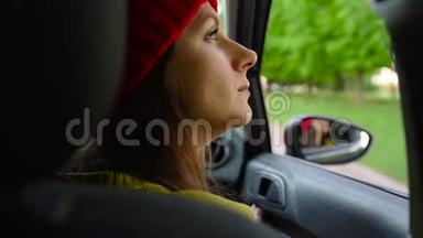 阳光明媚的一天，幸福的年轻女子坐在<strong>副驾驶</strong>座上看着窗外